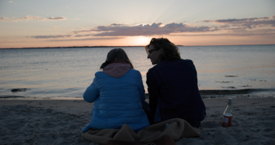 Twee mensen op het strand bij zonsondergang